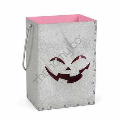 Galvanized metal Halloween jack-o-lantern pumpkin lantern bucket with a smiling face cutout and pink interior for farmhouse holiday decor.