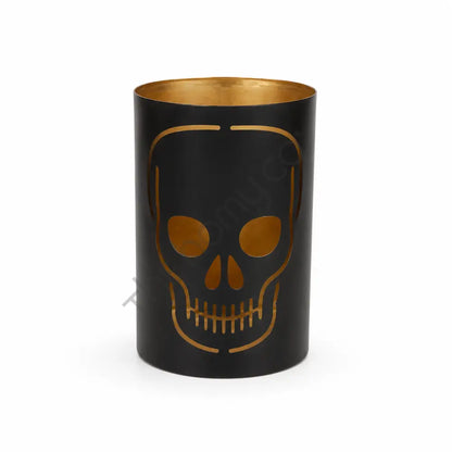Black metal skull candle holder with gothic cutout design and gold interior for Halloween decor.