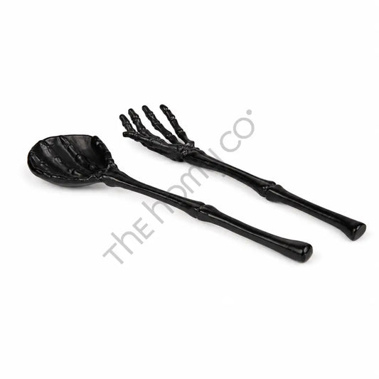 Black skeleton hand spoon and fork serving set with bone-inspired handles for Halloween party table decor.