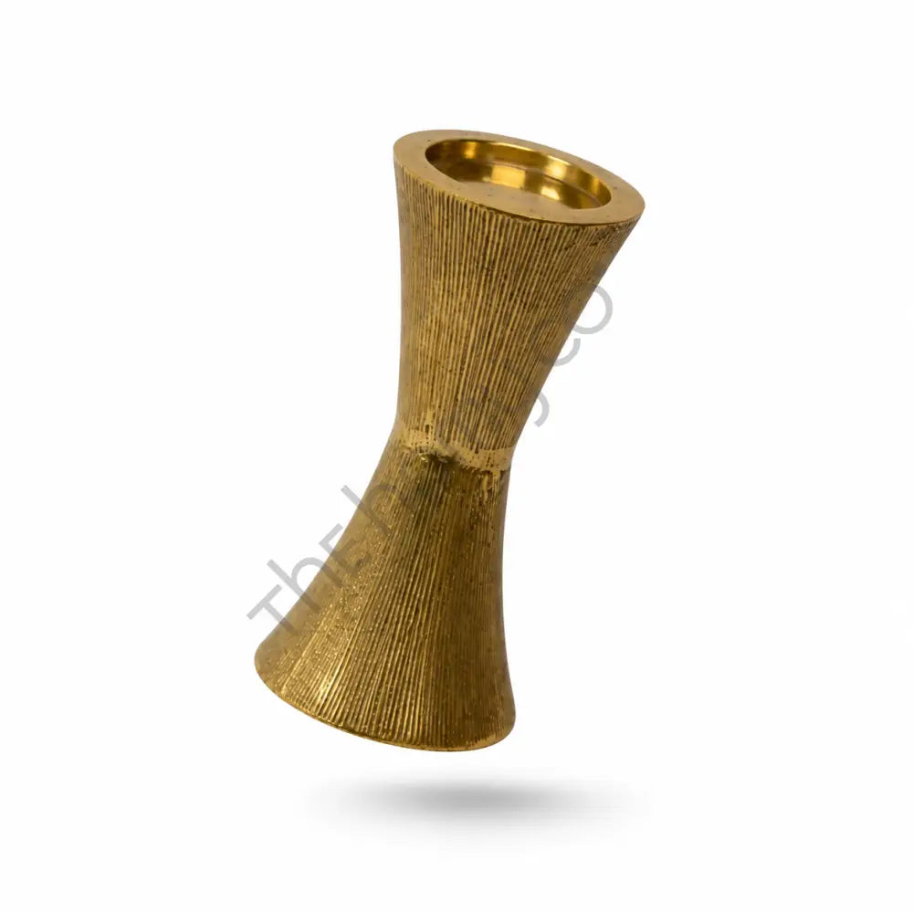 Elegant gold metal candle holder with a modern hourglass silhouette and textured finish for taper candles.