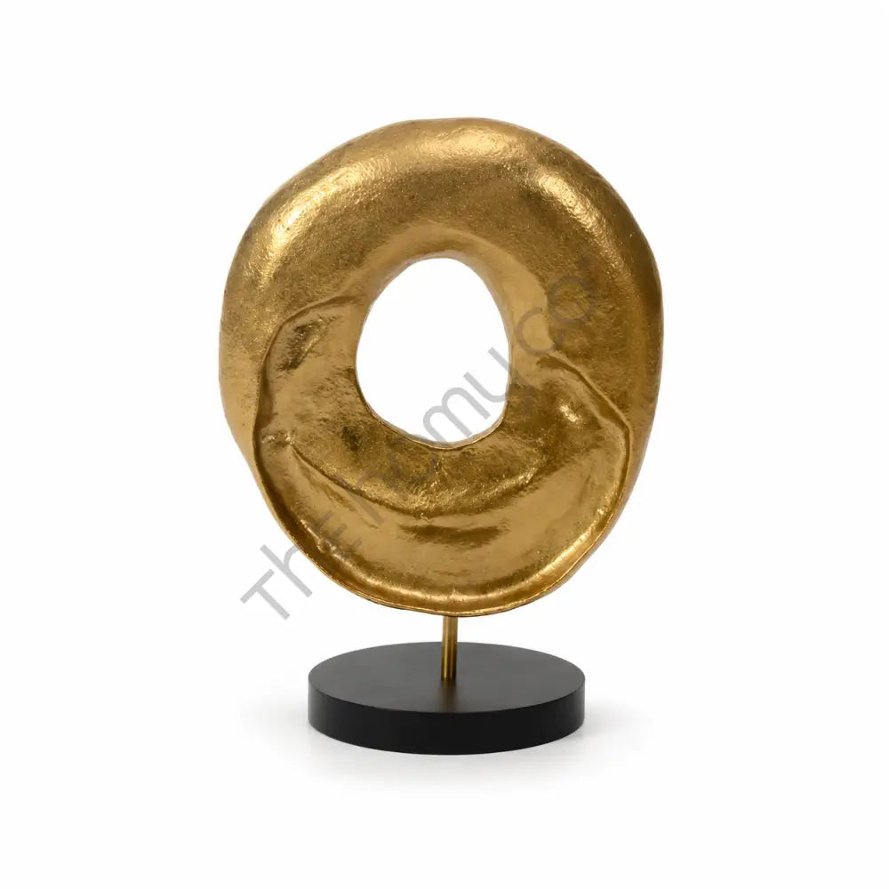 Modern abstract gold sculpture with a textured circular design on a matte black base for contemporary home decor.