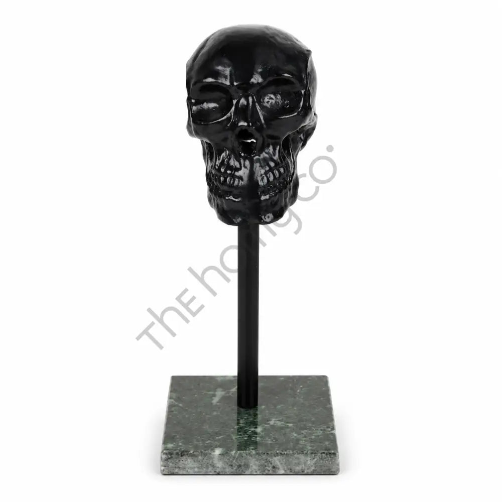 Modern black glossy skull sculpture on a marble base for contemporary home and office decor.