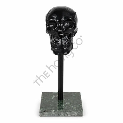 Modern black glossy skull sculpture on a marble base for contemporary home and office decor.