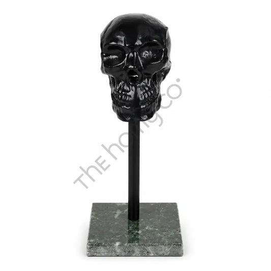 Modern black glossy skull sculpture on a marble base for contemporary home and office decor.