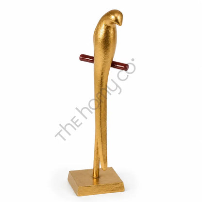 Modern gold metal parrot sculpture on a sleek stand for contemporary home and office decor.