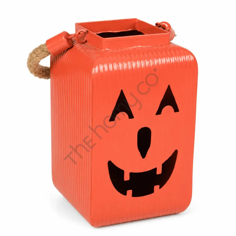 Orange pumpkin metal lantern with a jack-o-lantern face and rustic rope handles for Halloween decor.