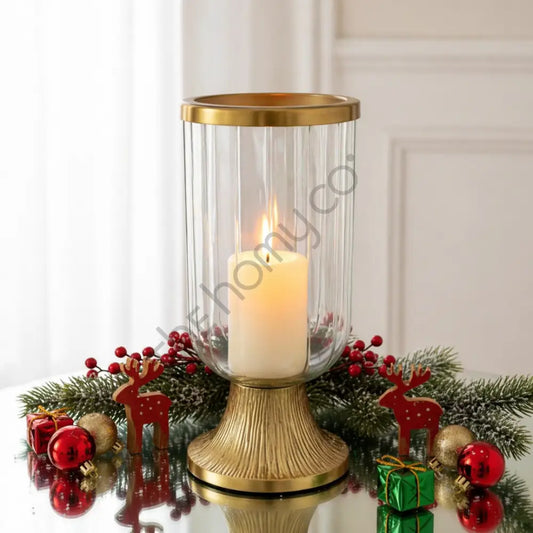 Ribbed glass hurricane candle holder with a gold metal base for elegant home decor.