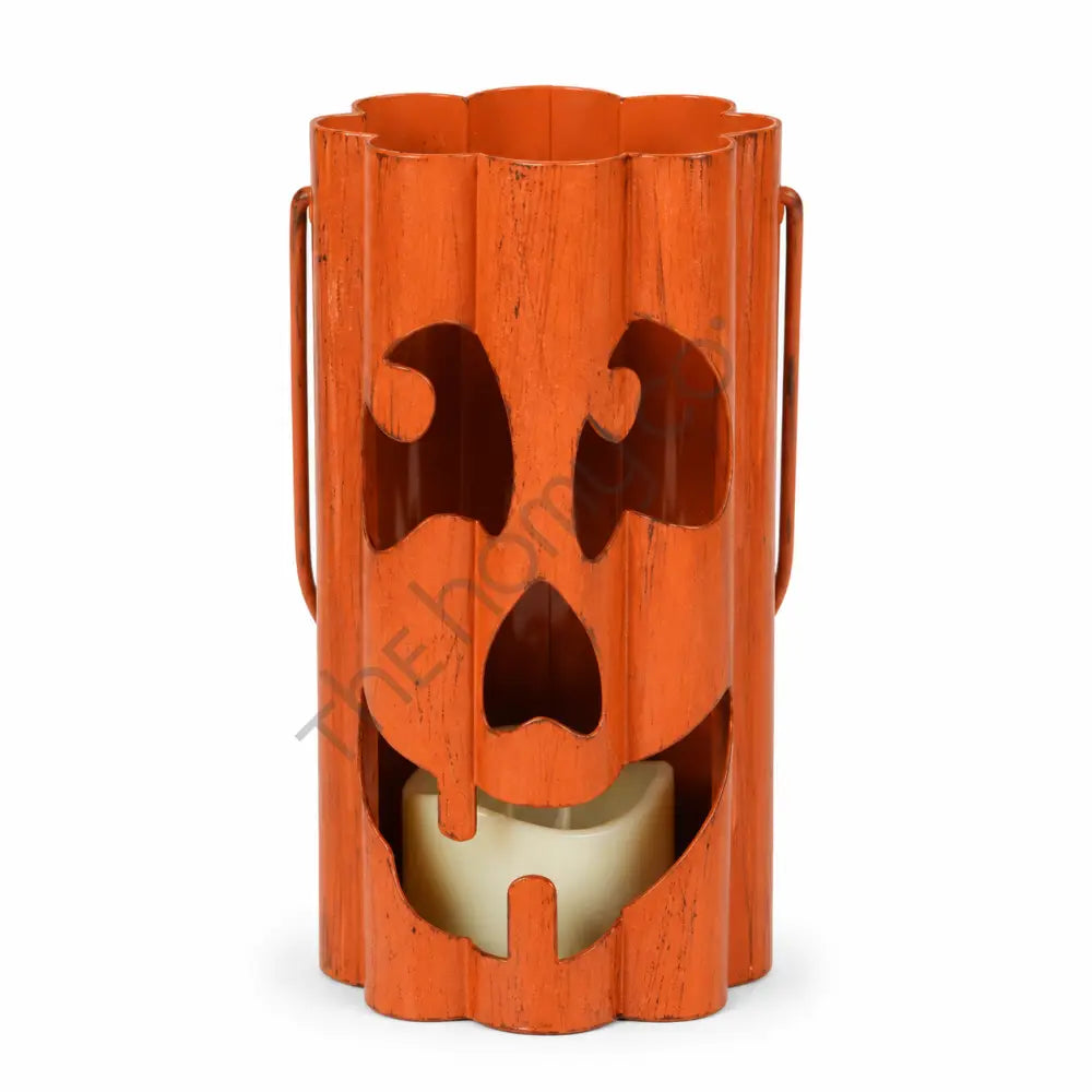 Rustic orange metal ghost face lantern with dripping cutout design for Halloween decor.