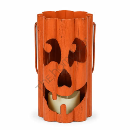Rustic orange metal ghost face lantern with dripping cutout design for Halloween decor.